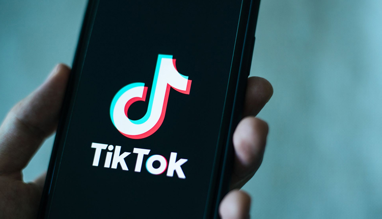 A hand holding mobile withTikTok application opened