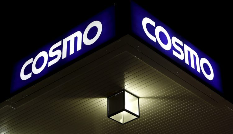 A light is seen under a signboard of Cosmo Energy Holdings' Cosmo Oil service station in Tokyo, Japan