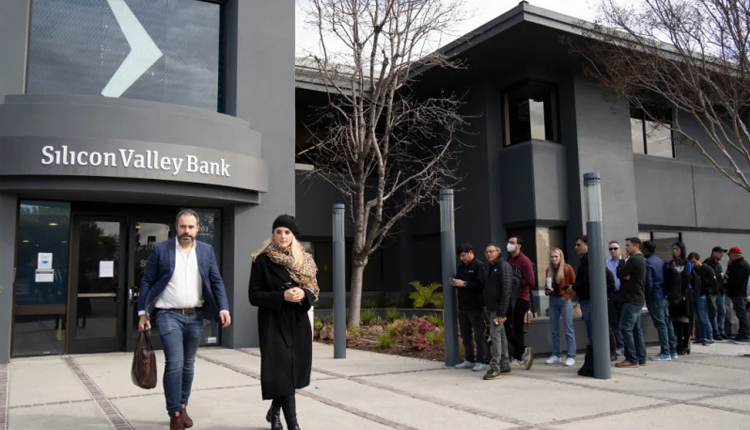 People queue up outside the headquarters of Silicon Valley Bank on March 13, 2023 in California