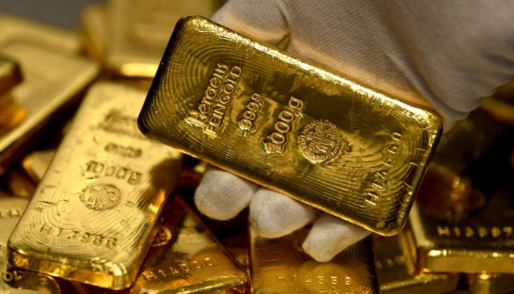 An employee holds a 1-kilogram gold bar in the precious metals vault at Pro Aurum KG in Munich, Germany