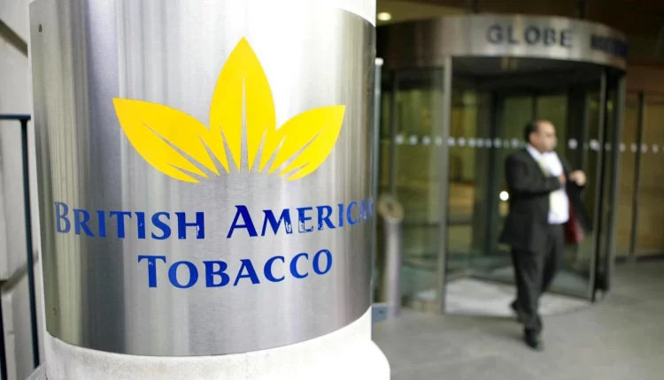 Man walking past a logo of British American Tobacco