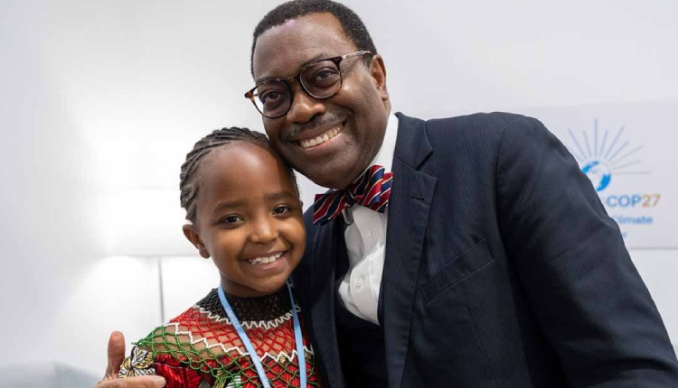 African Development Bank Group President Akinwumi Adesina congratulates young Karen Kimani for her passion for protecting the environment during COP27 in Egypt in November 2022